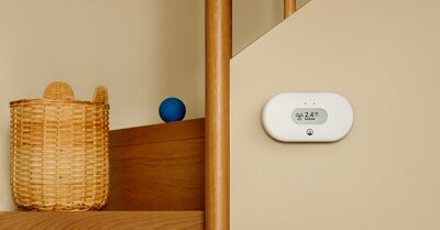 Airthings View Radon on a wall beside a staircase, showing a radon reading